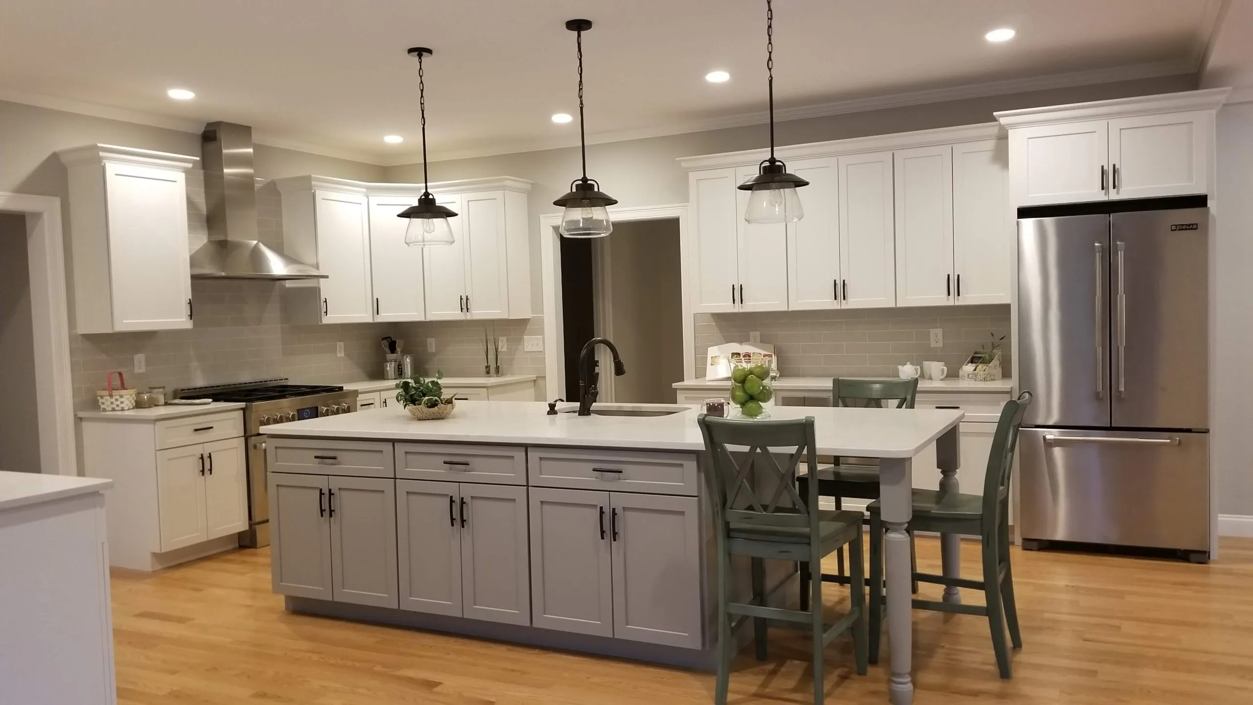 Open-concept kitchen remodel with white shaker cabinetry, a large island, and stainless appliances — the kind of period-home renovation CJM Builders does for Andover, MA homeowners