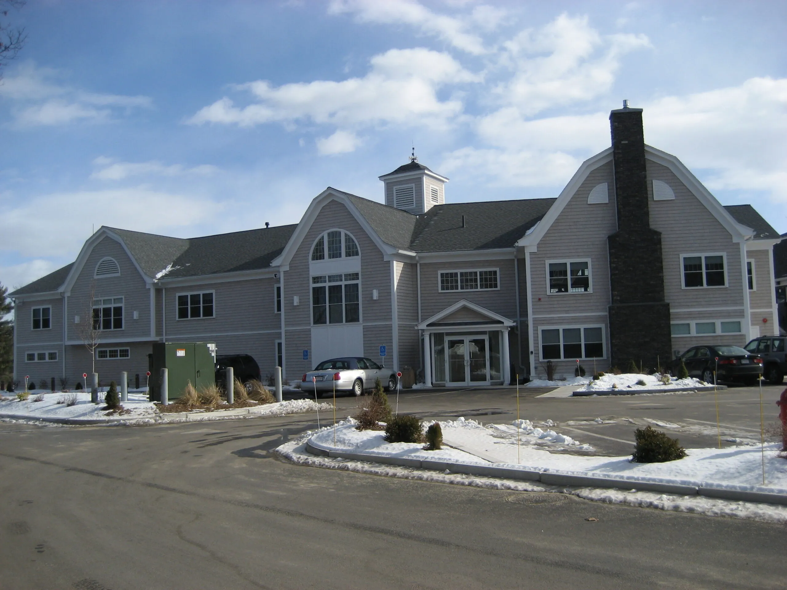 Sprawling custom home with multiple gabled rooflines, dormers, and attached garages