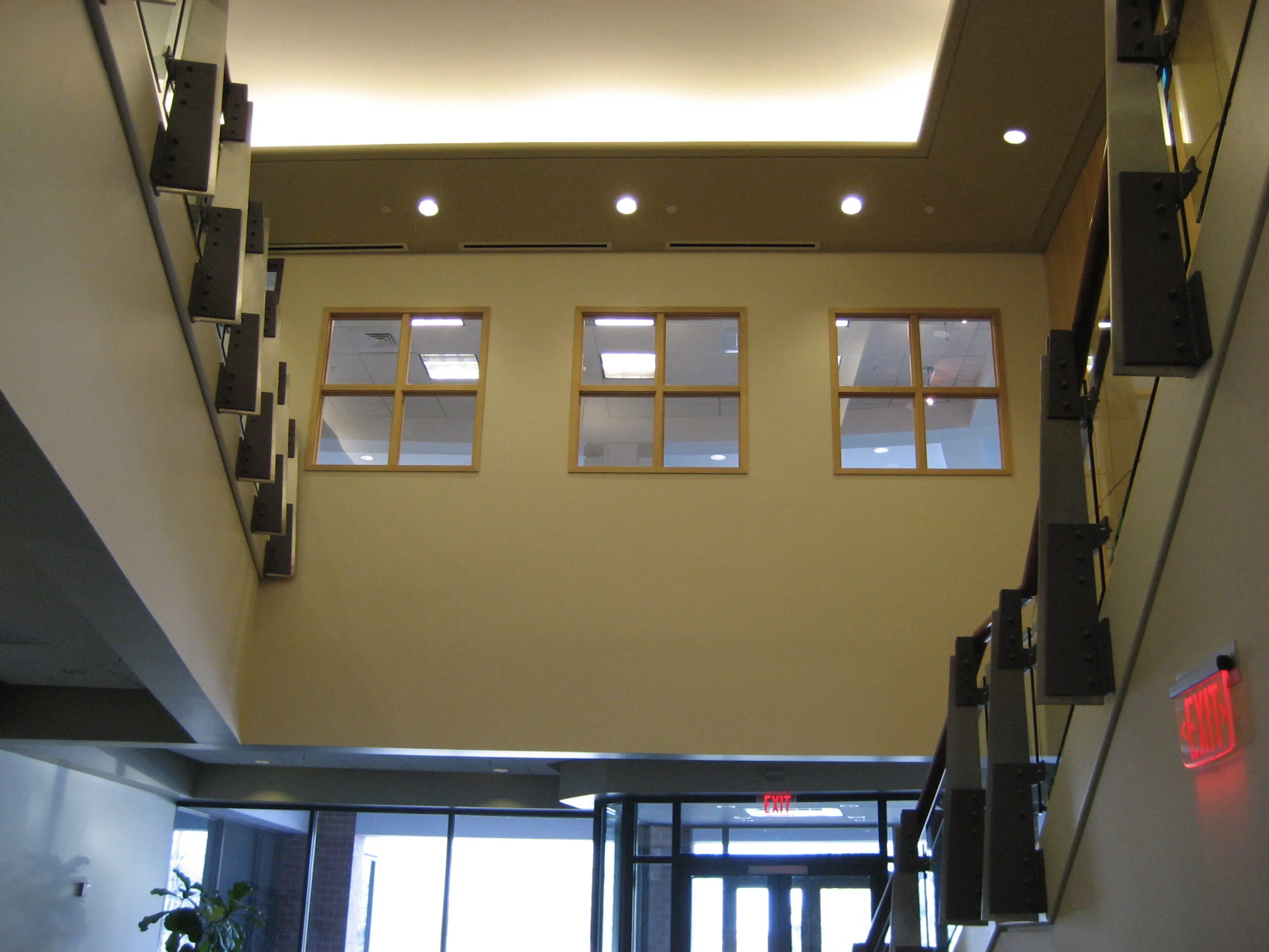 Two-story commercial interior with a wall of windows and an open staircase
