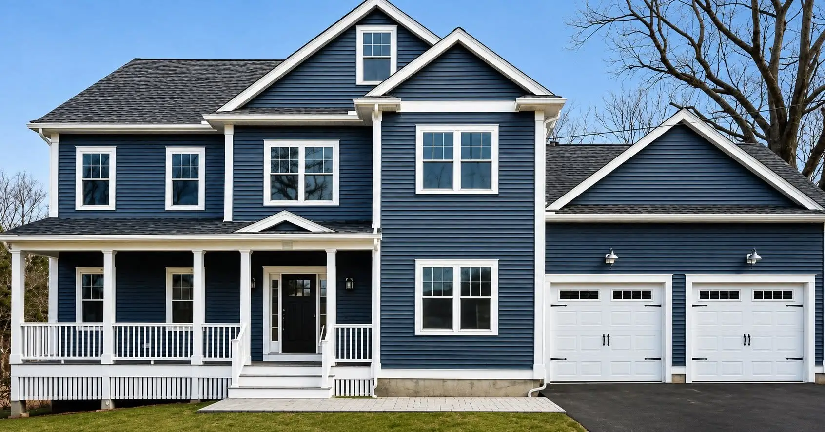 Navy colonial with a white farmer’s porch, white trim, and an attached two-car garage with white doors
