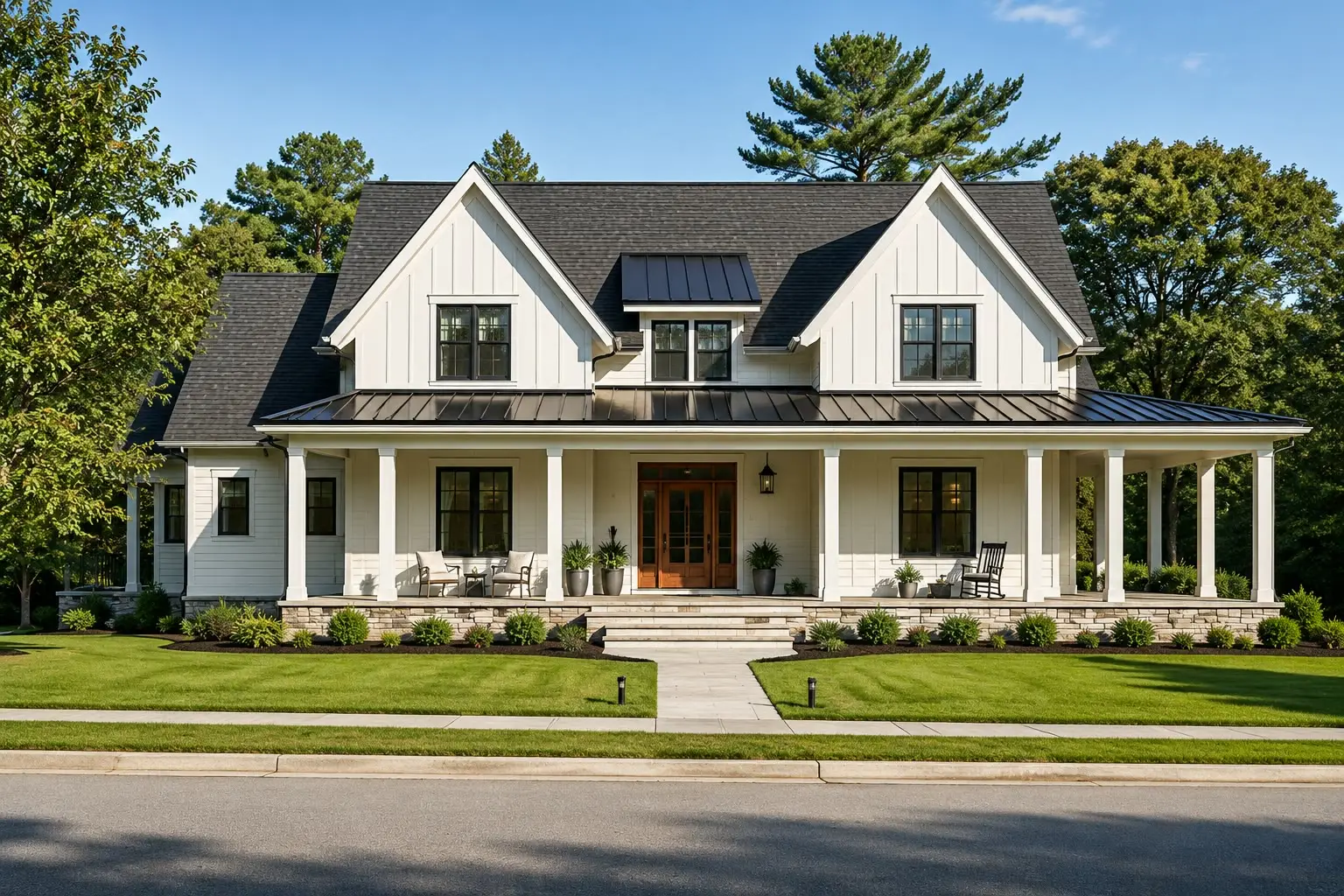 White modern farmhouse with board-and-batten siding, black windows, a full-width porch under a black standing-seam roof, stone piers, and a wood double door